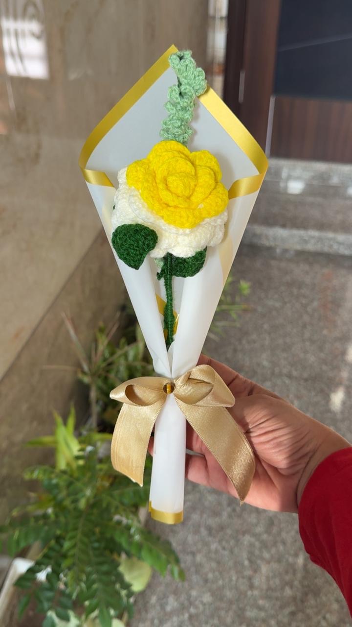 Single crochet yellow rose in a white paper cone with a gold ribbon