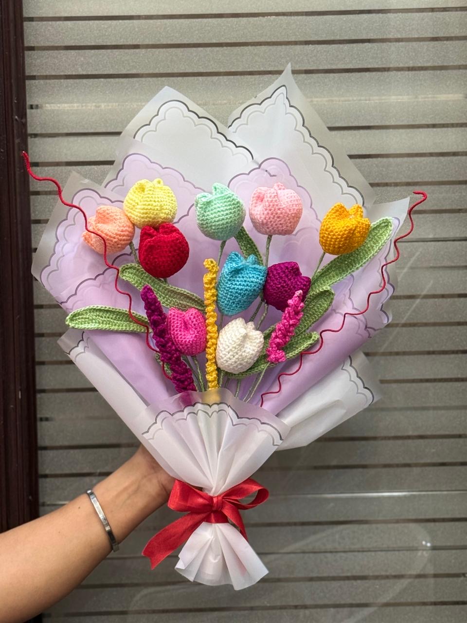 Large crochet tulip bouquet in rainbow colors wrapped in lilac and white paper