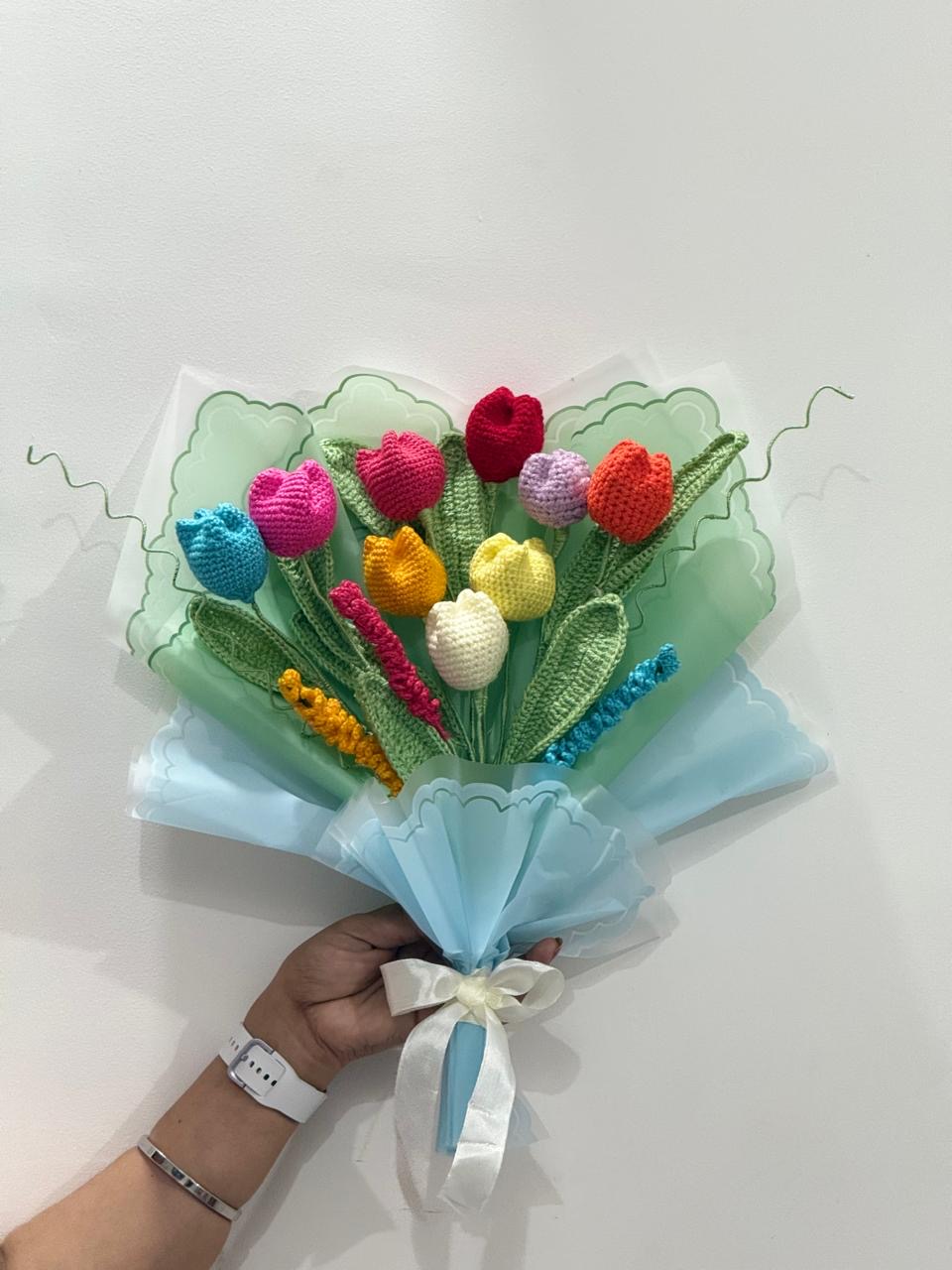 Crochet tulip bouquet in rainbow colors wrapped in mint green and blue paper